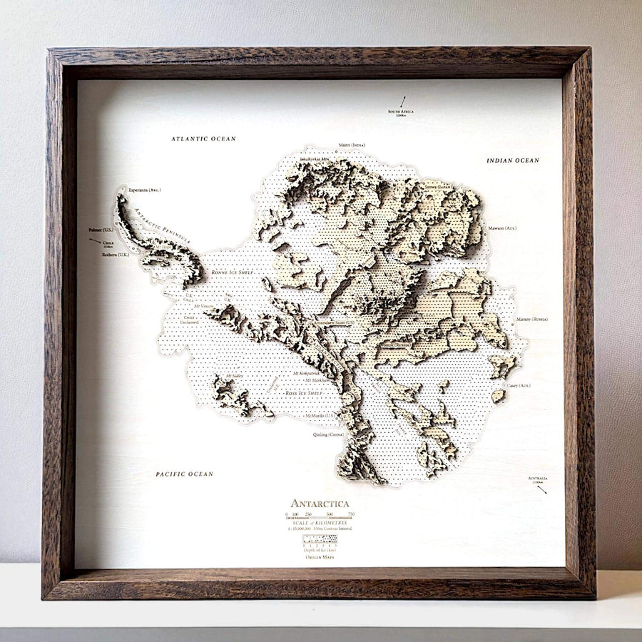 Framed topographic map of Antarctica on a white wall