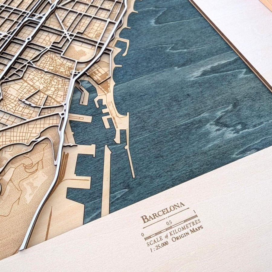 Wooden model of a city map with water body and 'Barcelona' branding.