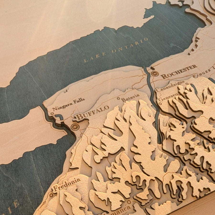 Wooden topographic map of Western New York with lakes and cities labeled