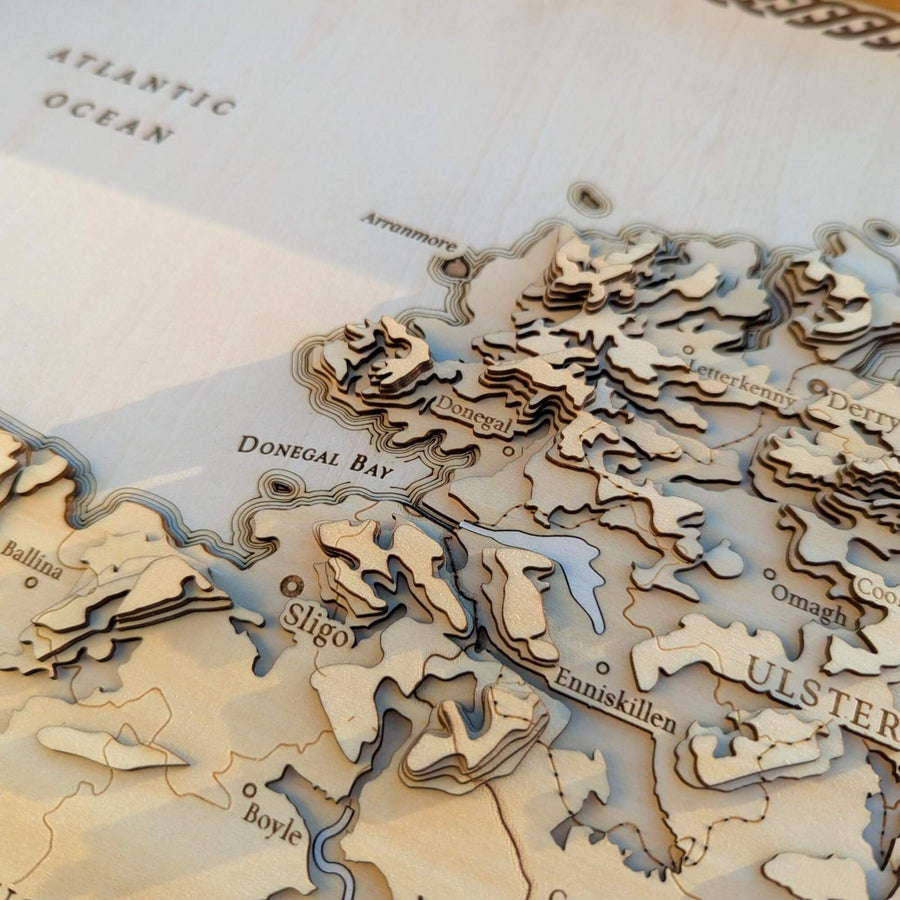 Wooden map of Ulster with cut-out regions on a white background