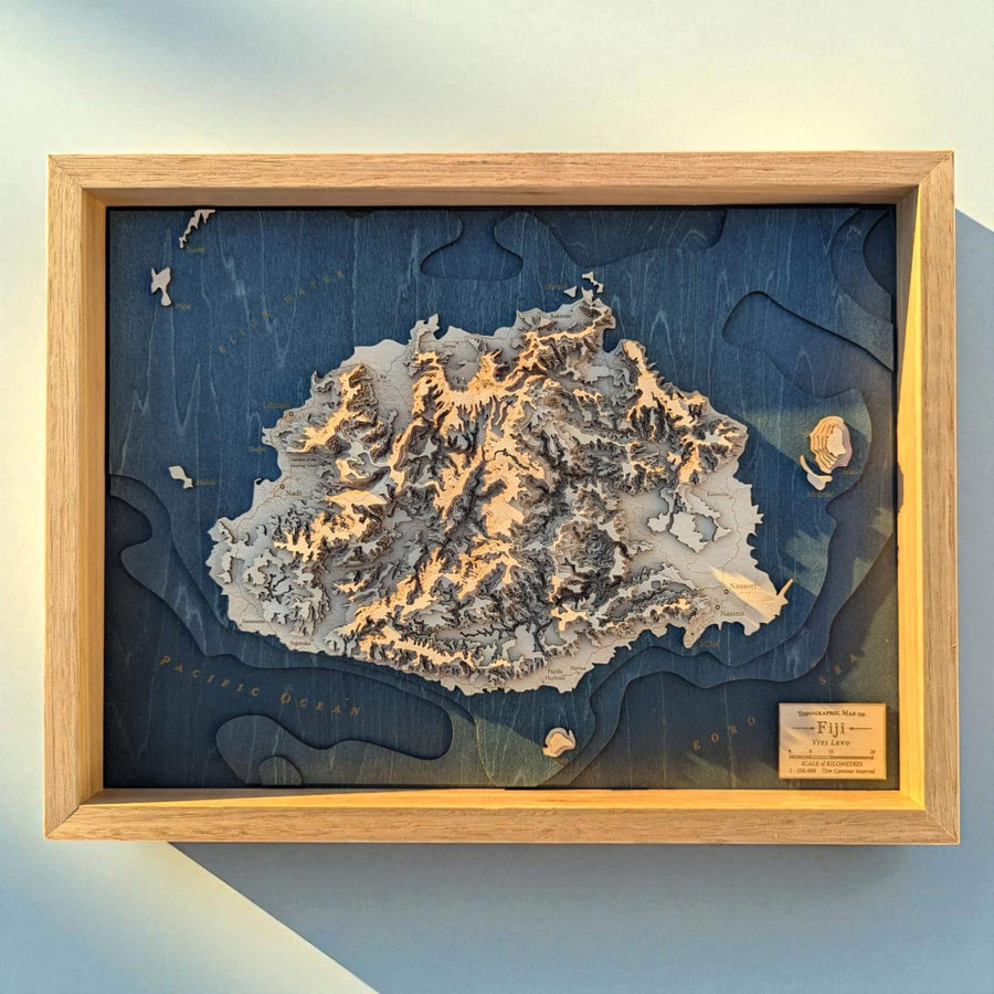 Topographic map of Fiji in a wooden frame on a light blue background