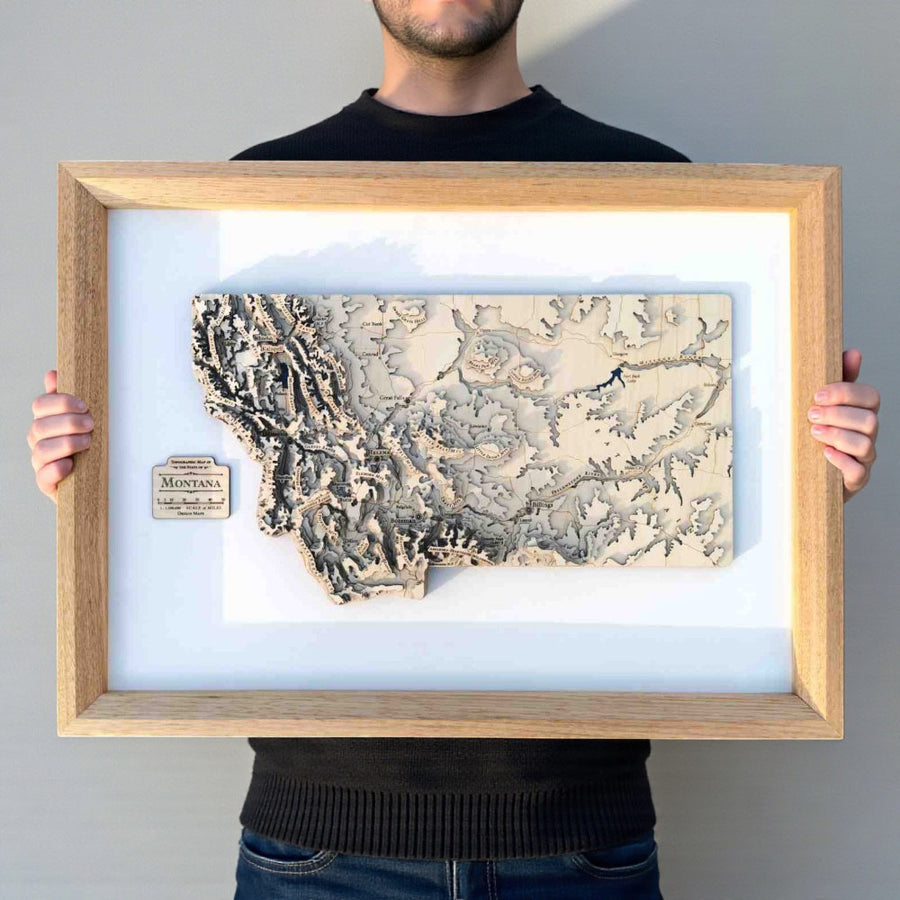Framed wooden map of Montana State USA held by a man