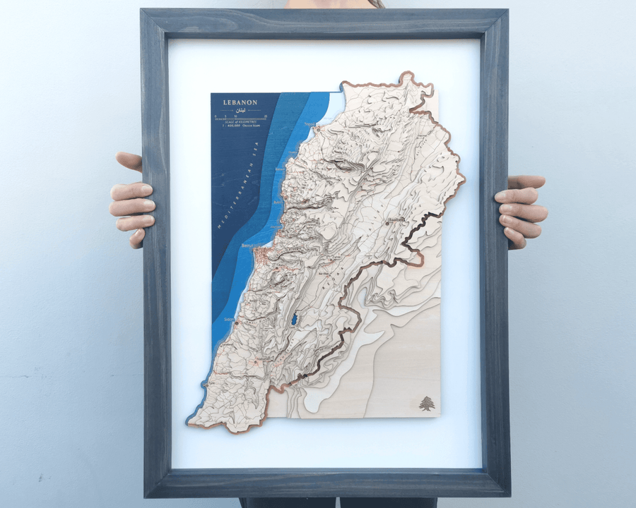 Wooden topographic framed map art of lebanon held by a girl