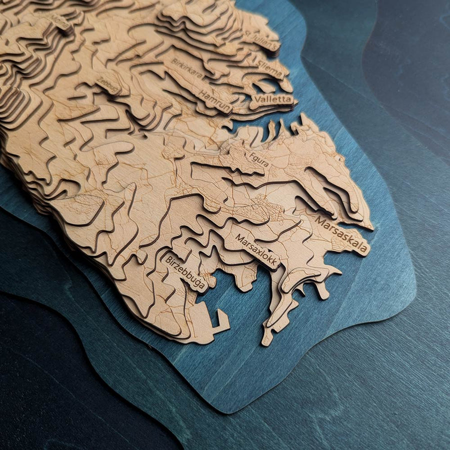 Wooden topographic map of Malta on a blue textured background