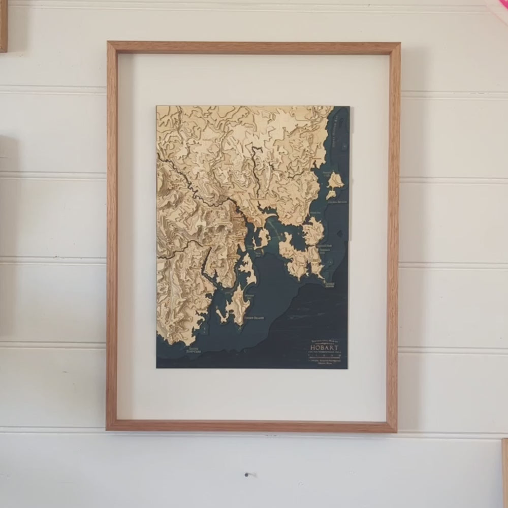 A video panning across a map of Hobart Tasmania as seen on a wooden topographic map